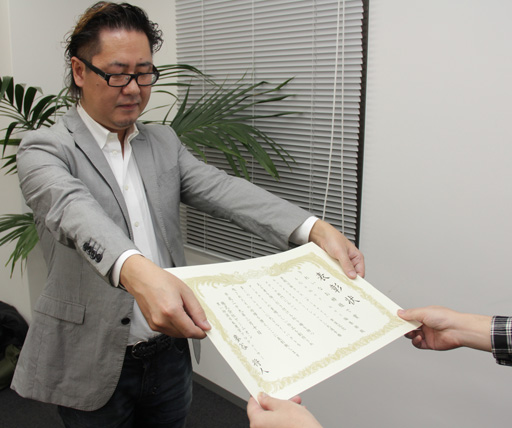 画像ギャラリー No.009のサムネイル画像 / 「黒い砂漠」運営プロデューサーが賞状と称号を持って編集部にやってきた。4Gamer作成のダークナイトは「きれいなお姉様で賞」を獲得